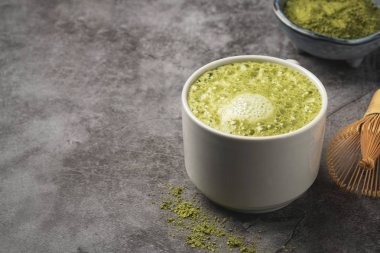 Latte matcha kahve. Japon matcha yeşil çay tozu, sağlıklı bir doğal ürün, antioksidan. Gri arka plan, yakın çekim, kopyalama alanı. 