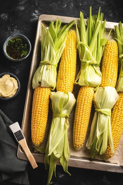 bir fırın tepsisine koçan üzerinde ham mısır, üst görünümü