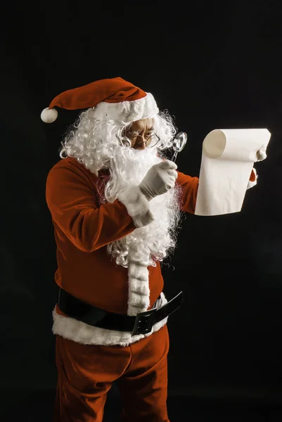 Santa Claus Lezing Giftlijst Voor Kinderen Studio Schoot Zwarte Achtergrond Rechtenvrije Stockfoto's