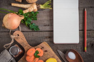 Yemek pişirmek için malzemeler: sebze, baharat ve ahşap zemin üzerine bir not defteri. Kopya alanı.