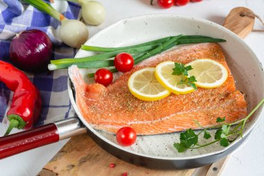 Limon ve kiraz domates yemek için hazır bir tavada taze somon.