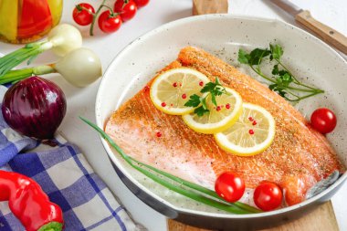 Limon ve kiraz domates yemek için hazır bir tavada taze somon.