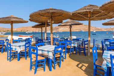 Serifos, Yunanistan - 9 Eylül, 2018: masa ve sandalyeler Livadi şehirdeki plajda geleneksel Yunan meyhanede. Serifos island, Yunanistan