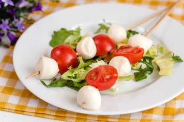 Domates ve mozzarella peynirli çubuk üzerinde meze.