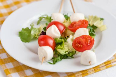 Domates ve mozzarella peynirli çubuk üzerinde meze.