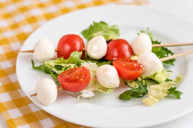 Domates ve mozzarella peynirli çubuk üzerinde meze.