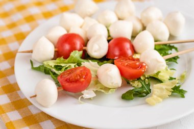Domates ve mozzarella peynirli çubuk üzerinde meze.