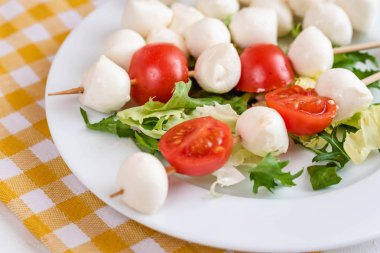 Domates ve mozzarella peynirli çubuk üzerinde meze.