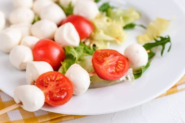 Domates ve mozzarella peynirli çubuk üzerinde meze.