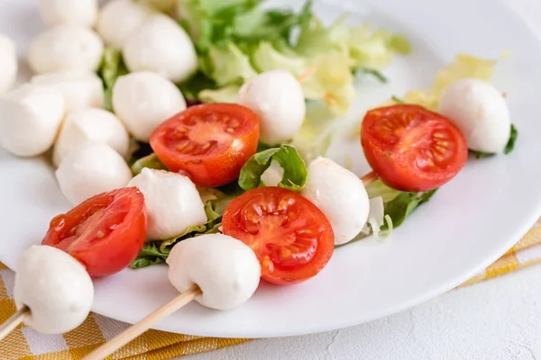Domates ve mozzarella peynirli çubuk üzerinde meze.
