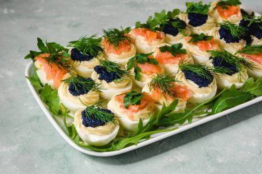 Somon ve maydanoz ve dereotu ile dekore edilmiş havyar ile yumurta dolması. Parti gıda