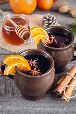 Portakal, tarçın, bal ve ahşap arka plan üzerinde anason ile sıcak mulled şarap.