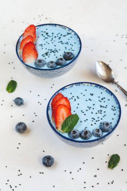 Mavi spirulina tozu, çilek ve yaban mersini ile yapılan mavi yoğurt güler yüzlü.