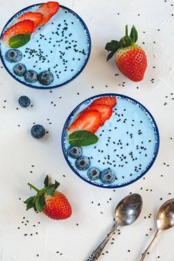 Mavi spirulina tozu, çilek ve yaban mersini ile yapılan mavi yoğurt güler yüzlü.