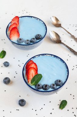 Mavi spirulina tozu, çilek ve yaban mersini ile yapılan mavi yoğurt güler yüzlü.