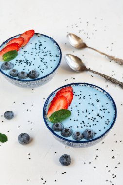 Mavi spirulina tozu, çilek ve yaban mersini ile yapılan mavi yoğurt güler yüzlü.