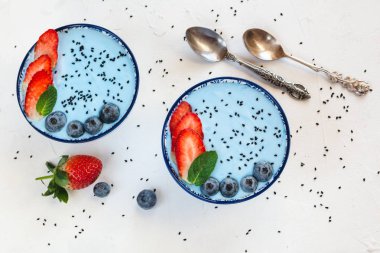 Mavi spirulina tozu, çilek ve yaban mersini ile yapılan mavi yoğurt güler yüzlü.