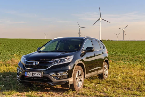 Puck, Polonya - 18 Eylül 2018: köy yolunda bir rüzgar çiftliği yanındaki alanda Park Honda Cr-V araba