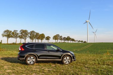 Puck, Polonya - 18 Eylül 2018: köy yolunda bir rüzgar çiftliği yanındaki alanda Park Honda Cr-V araba