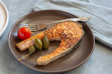 Kızarmış somon tabağı Kapari elma ve domates ile servis.