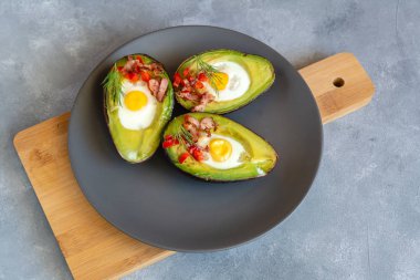 Avokado bacon, kırmızı pul biber ve dereotu ile bıldırcın yumurtası pişmiş.