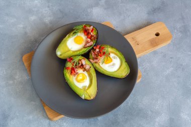 Avokado bacon, kırmızı pul biber ve dereotu ile bıldırcın yumurtası pişmiş.