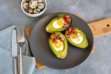 Avokado bacon, kırmızı pul biber ve dereotu ile bıldırcın yumurtası pişmiş.