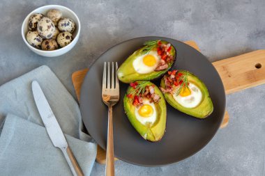 Avokado bacon, kırmızı pul biber ve dereotu ile bıldırcın yumurtası pişmiş.