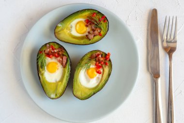Avokado bacon, kırmızı pul biber ve dereotu ile bıldırcın yumurtası pişmiş.