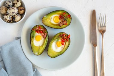 Avokado bacon, kırmızı pul biber ve dereotu ile bıldırcın yumurtası pişmiş.