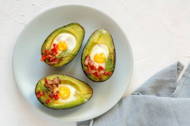 Avokado bacon, kırmızı pul biber ve dereotu ile bıldırcın yumurtası pişmiş.