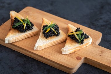 Siyah havyar limon hapı ve dereotu ile dekore edilmiş meze tost ekmeği