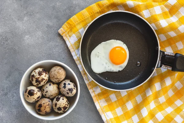 Quail egg fried in a pan. Fresh organic egg.