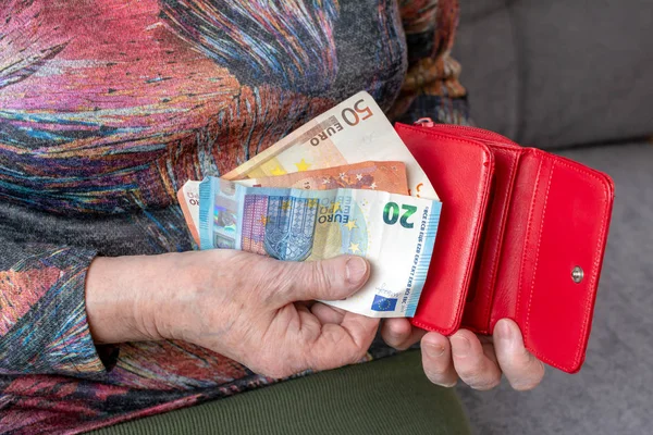 Hände einer älteren Rentnerin, die eine lederne Geldbörse mit Eurogeld in der Hand hält. Konzept der finanziellen Absicherung im Alter. — Stockfoto