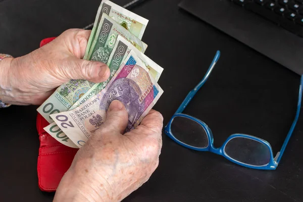 Τα χέρια της μια ηλικιωμένη συνταξιούχος κρατώντας δερμάτινο πορτοφόλι με χρήματα νόμισμα Πολωνικά. Έννοια της οικονομική ασφάλεια στα γεράματα. — Φωτογραφία Αρχείου