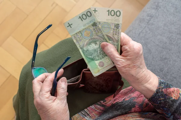 Eller deri cüzdan Polonya para birimi para ile tutarak bir yaşlı emekli. Yaşlılıkta Finansal güvenlik kavramı.