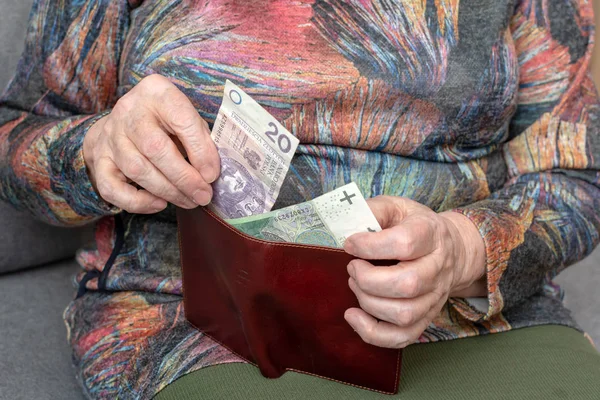 Τα χέρια της μια ηλικιωμένη συνταξιούχος κρατώντας δερμάτινο πορτοφόλι με χρήματα νόμισμα Πολωνικά. Έννοια της οικονομική ασφάλεια στα γεράματα. — Φωτογραφία Αρχείου