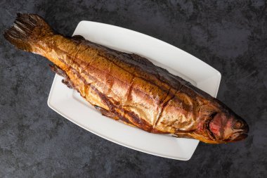 Karanlık bir arka plan üzerinde alabalık balık füme