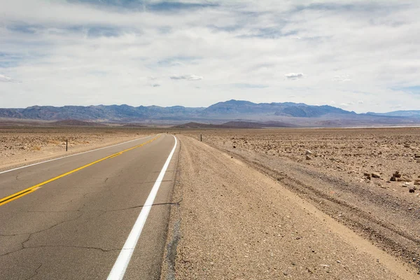 Estrada do Vale da Morte através do deserto para as montanhas à distância. Califórnia, EUA — Fotografia de Stock