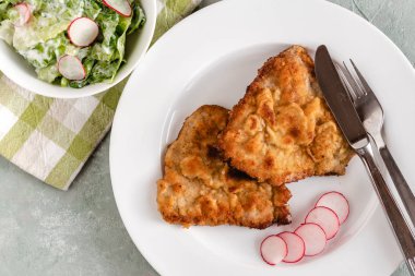 Turp ve marul ile servis ekmek kırıntıları kızarmış domuz pirzolası.