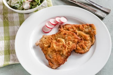 Turp ve marul ile servis ekmek kırıntıları kızarmış domuz pirzolası.