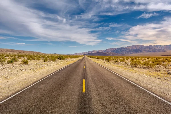 Estrada através de um deserto e montanhas na Califórnia, EUA — Fotografia de Stock