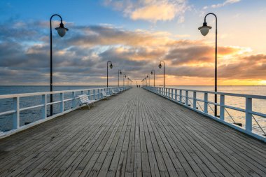 Sabah Gdynia Orlowo 'daki ahşap iskelede gün doğumunun renkleriyle. Polonya. Avrupa.
