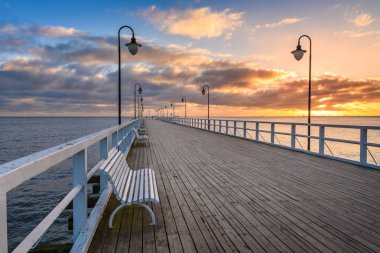 Sabah Gdynia Orlowo 'daki ahşap iskelede gün doğumunun renkleriyle. Polonya. Avrupa.
