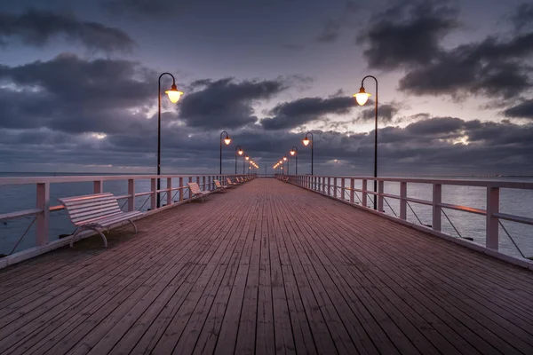 Molo di legno illuminato a Gdynia Orlowo. La mattina presto sul Mar Baltico. Polonia, Europa . — Foto Stock