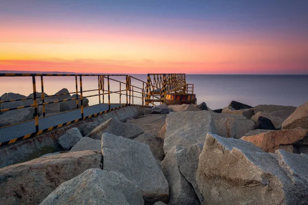 Un frangiflutti roccioso che si affaccia sul golfo di Danzica vicino alla spiaggia di Westerplatte al tramonto. Danzica, Polonia — Foto Stock