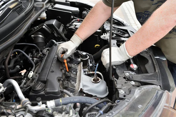 BEDZIN, POLONIA - 15 de julio de 2019: Hombre comprobando el nivel de aceite en el motor del automóvil Honda CR-V . — Foto de Stock