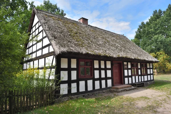 Old whitewashed house with thatched roof in The Folk Culture Museum in Osiek by the river Notec, the ethnographic park covers an area of 13 ha. Poland, Europe