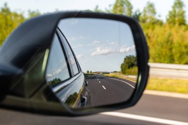 Asfalt yol araç aynasına yansıdı. Güvenli sürüş kavramı.