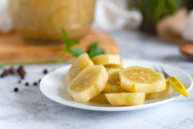 Mutfak masasında bir tabakta marine salatalık